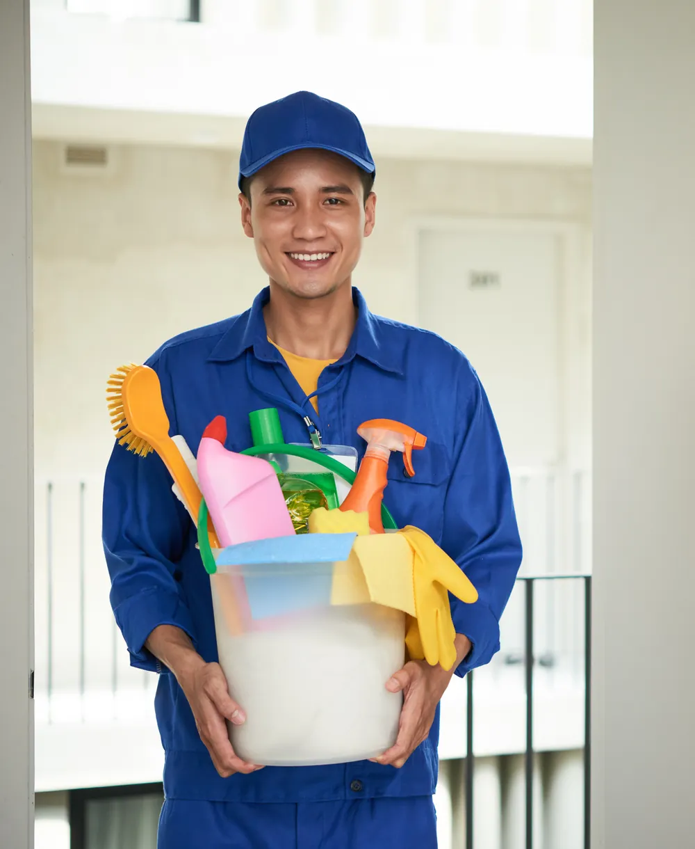 Colaborador de Top Cleaners con uniforme azul cargando productos y jarcería de limpieza